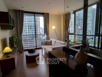 Modern living room with large windows and city view, featuring cozy seating and stylish decor.