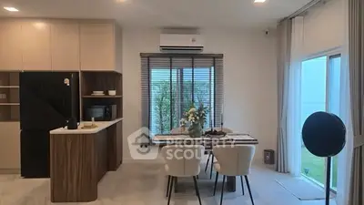 Modern kitchen and dining area with sleek design and natural light