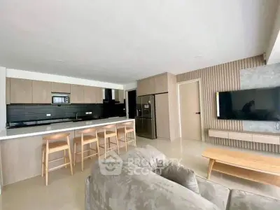 Modern open-layout kitchen and living room with sleek design and neutral tones.
