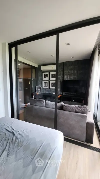 Modern living room with glass partition and stylish decor in a contemporary apartment.