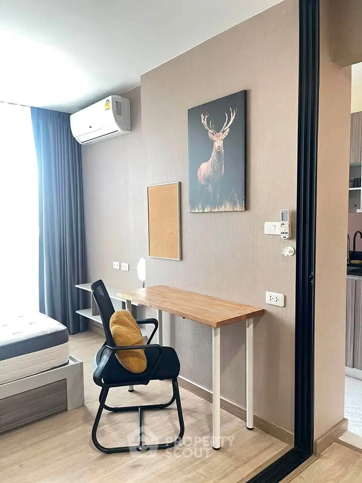 Modern studio apartment with stylish decor and natural light, featuring a cozy workspace and comfortable bed.