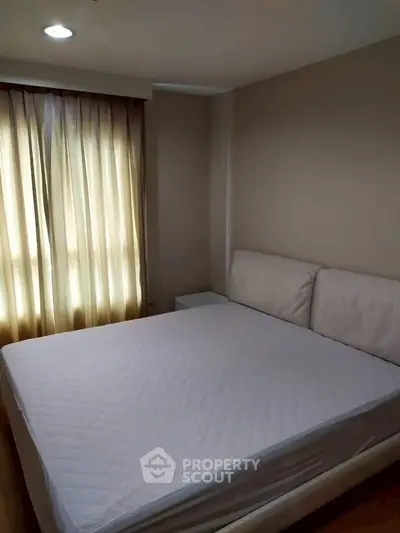 Cozy bedroom with soft lighting and elegant curtains, perfect for relaxation.