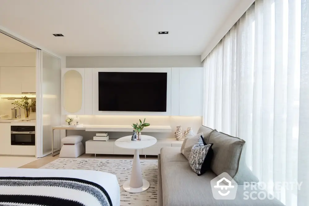 Modern living room with sleek design, large TV, and cozy seating area in a bright apartment.