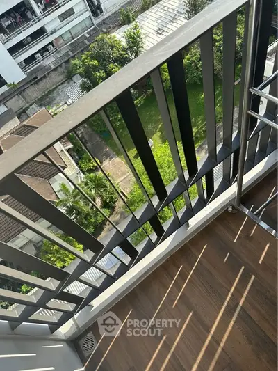 Charming balcony view overlooking lush greenery in a modern apartment setting.