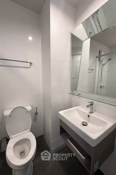 Modern bathroom with sleek white tiles and contemporary fixtures.