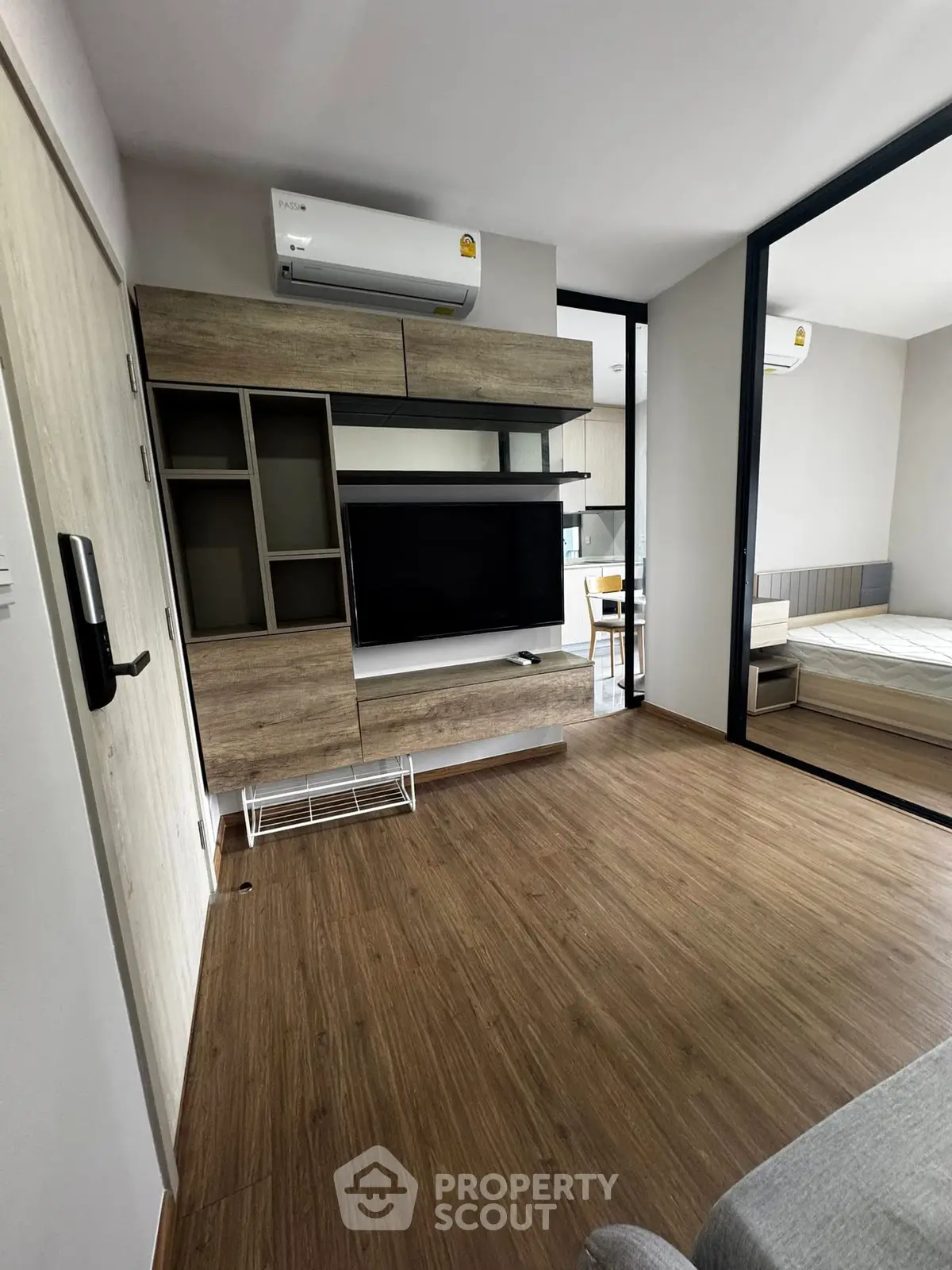 Modern living room with wooden flooring and built-in TV unit in a stylish apartment.