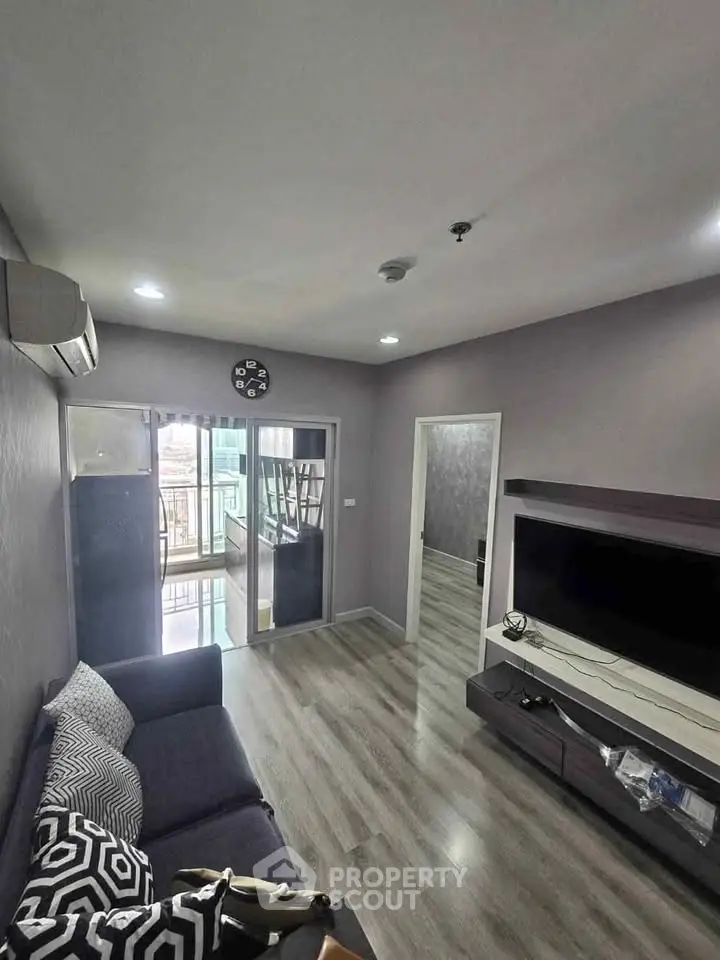 Modern living room with sleek design and balcony access in a stylish apartment.