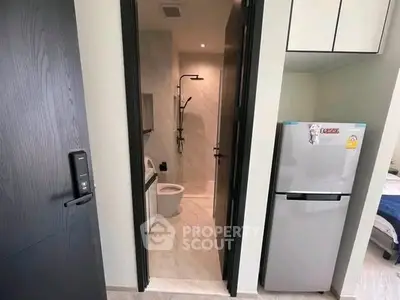 Modern apartment interior with bathroom and kitchen area featuring sleek design and contemporary appliances.