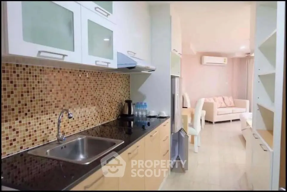 Modern kitchen with mosaic backsplash and open layout leading to living area