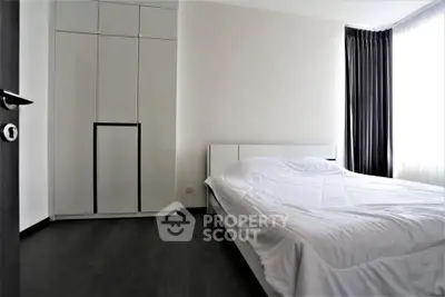 Modern minimalist bedroom with sleek wardrobe and natural light