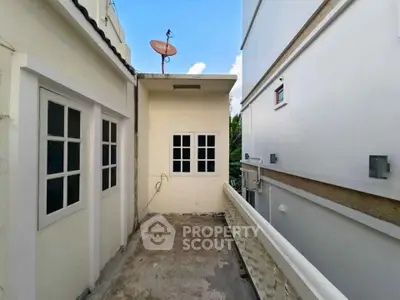 Charming balcony space with potential for outdoor relaxation, nestled between two buildings.
