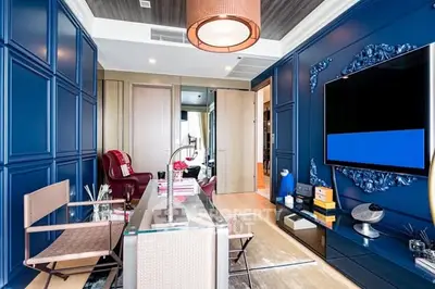 Luxurious modern living room with stylish blue accents and large flat-screen TV.