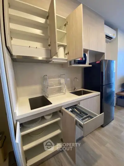 Modern kitchen with open cabinets and sleek appliances, showcasing efficient storage solutions.