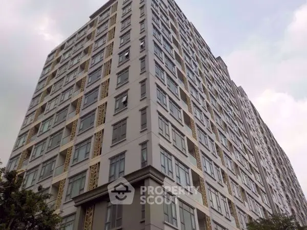 Modern high-rise building with sleek architecture and numerous windows, ideal for urban living.