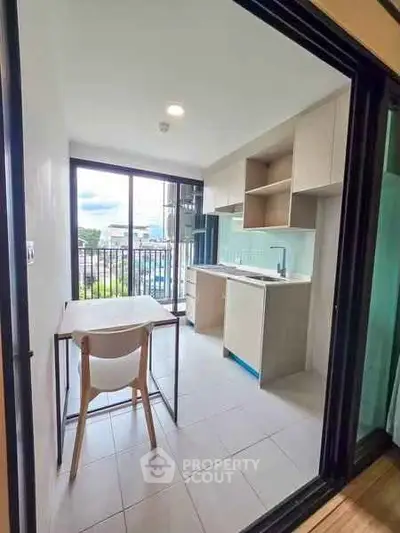 Modern kitchen with open layout and balcony view in urban apartment