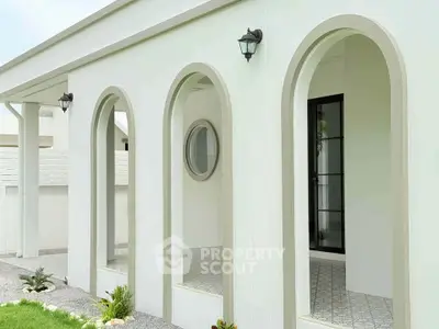 Elegant modern building exterior with stylish arches and contemporary lighting.