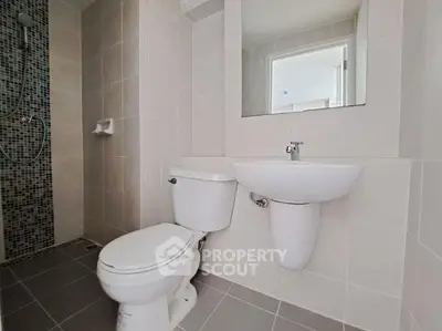 Modern bathroom with sleek fixtures and tiled shower area.