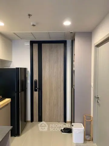 Modern kitchen entrance with sleek black fridge and minimalist design