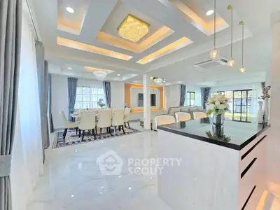 Luxurious open-plan living and dining area with elegant chandeliers and modern decor.