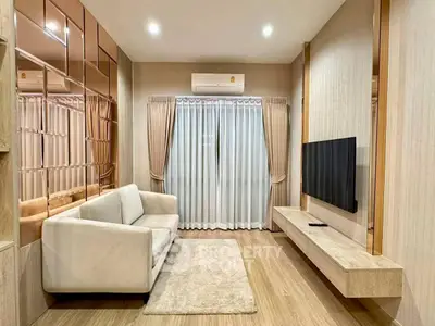 Modern living room with sleek design, featuring a cozy sofa, wall-mounted TV, and elegant curtains.