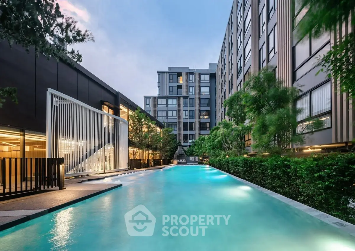 Luxurious modern apartment complex with stunning outdoor pool and lush greenery.