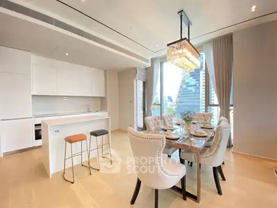 Luxurious open-plan kitchen and dining area with elegant chandelier and city view.