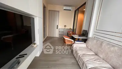 Modern living room with sleek design, featuring a large TV, stylish furniture, and elegant decor.