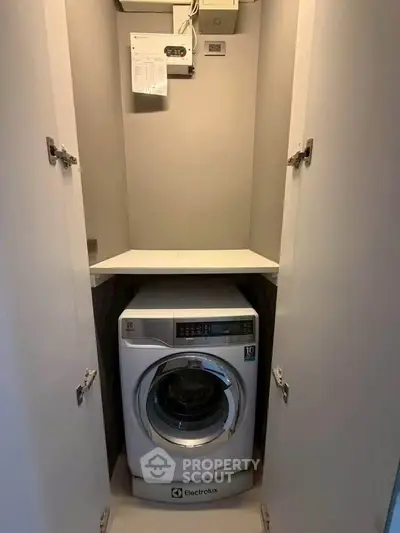 Compact laundry space with Electrolux washing machine in a modern apartment.