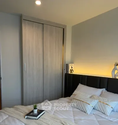 Cozy bedroom with modern decor and soft lighting, featuring a stylish bed and built-in wardrobe.