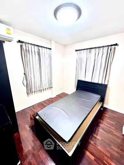 Cozy bedroom with wooden flooring and modern lighting