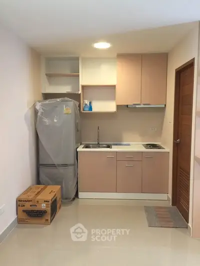 Modern compact kitchen with fridge and oven in a cozy apartment