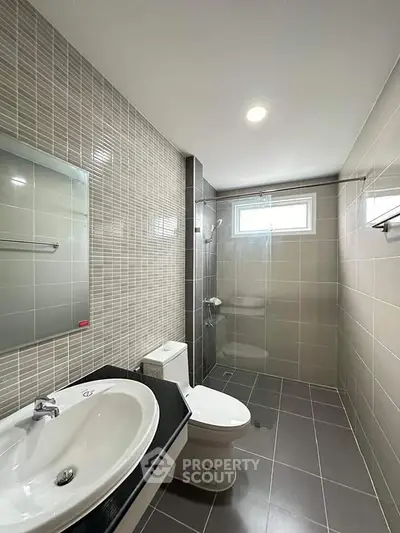 Modern bathroom with sleek tiles and glass shower enclosure