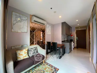 Stylish modern living room with open kitchen and elegant decor in a cozy apartment.