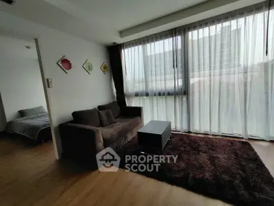 Modern living room with large windows and cozy sofa in stylish apartment.