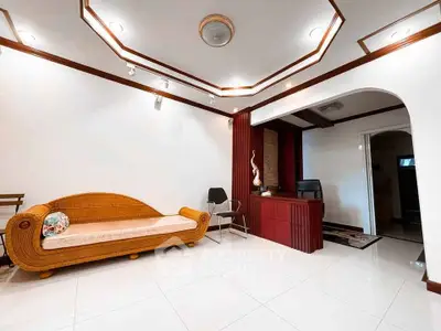 Elegant living room with unique wicker sofa and stylish ceiling design.