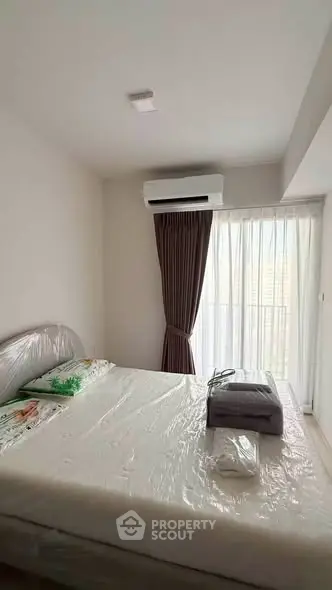 Modern bedroom with air conditioning and large window in a high-rise apartment.