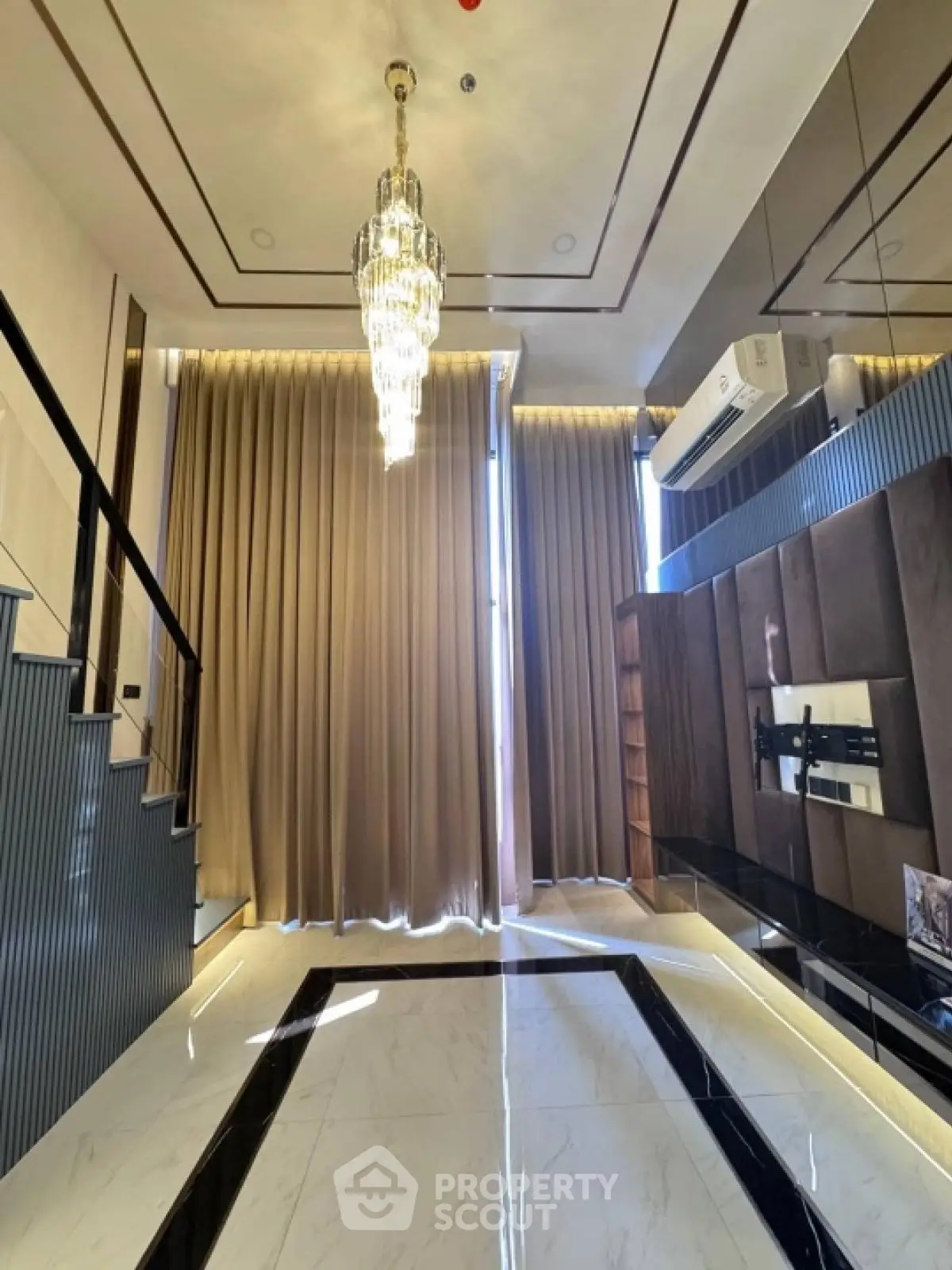 Luxurious modern living room with chandelier and elegant staircase