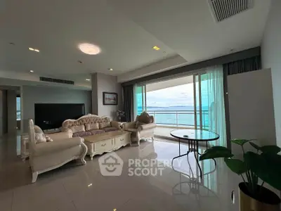 Luxurious living room with elegant furniture and stunning ocean view from large balcony.