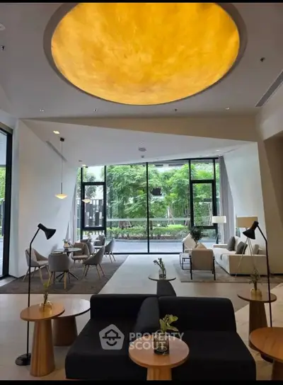 Luxurious modern living room with elegant furniture and large windows overlooking a lush garden.