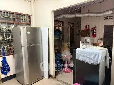 Cozy kitchen space with stainless steel fridge and open layout, featuring practical appliances and homey decor.