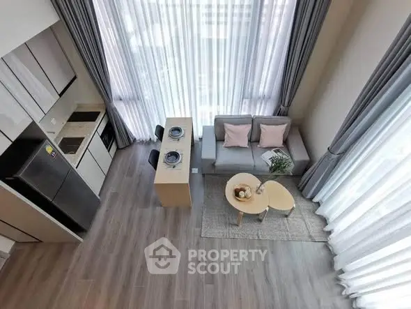 Modern loft-style living room with high ceilings and large windows