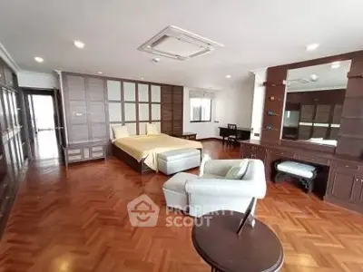 Spacious bedroom with elegant wooden flooring and modern furnishings