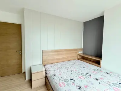 Modern bedroom with stylish wooden furniture and playful bedding in a bright apartment.