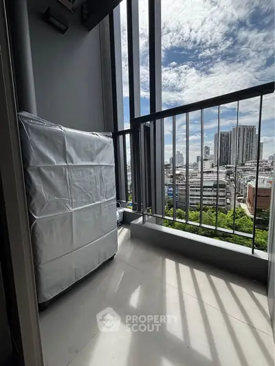 Modern balcony with city skyline view and covered appliance, perfect for urban living.