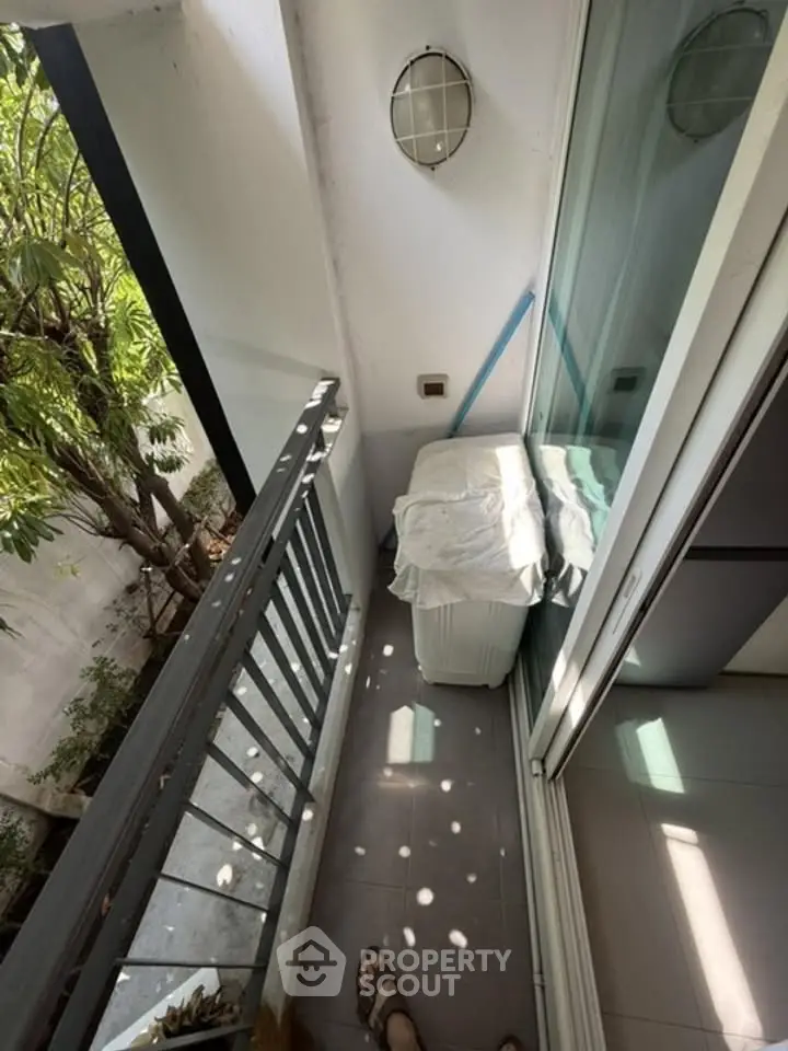 Charming small balcony with natural light and garden view, perfect for relaxation.