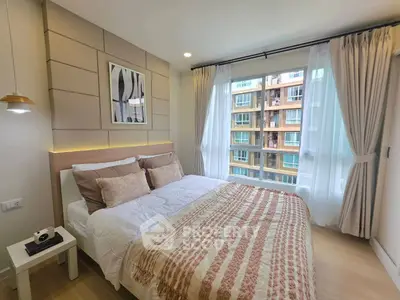 Modern bedroom with large window and stylish decor in a high-rise apartment.