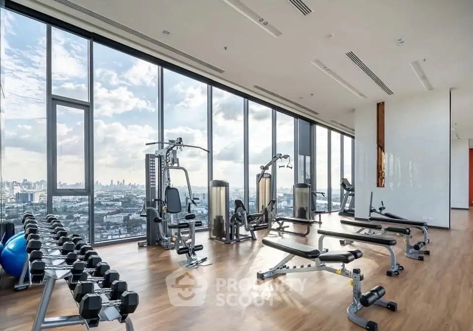 Luxurious high-rise gym with panoramic city views and modern fitness equipment.
