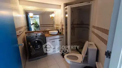 Modern bathroom with washing machine and shower in stylish apartment.
