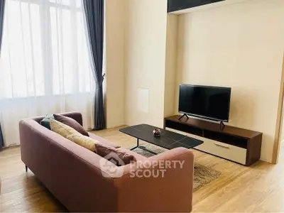 Spacious living room with modern decor and large window for natural light.