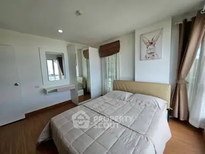 Cozy bedroom with modern decor and large windows for natural light.